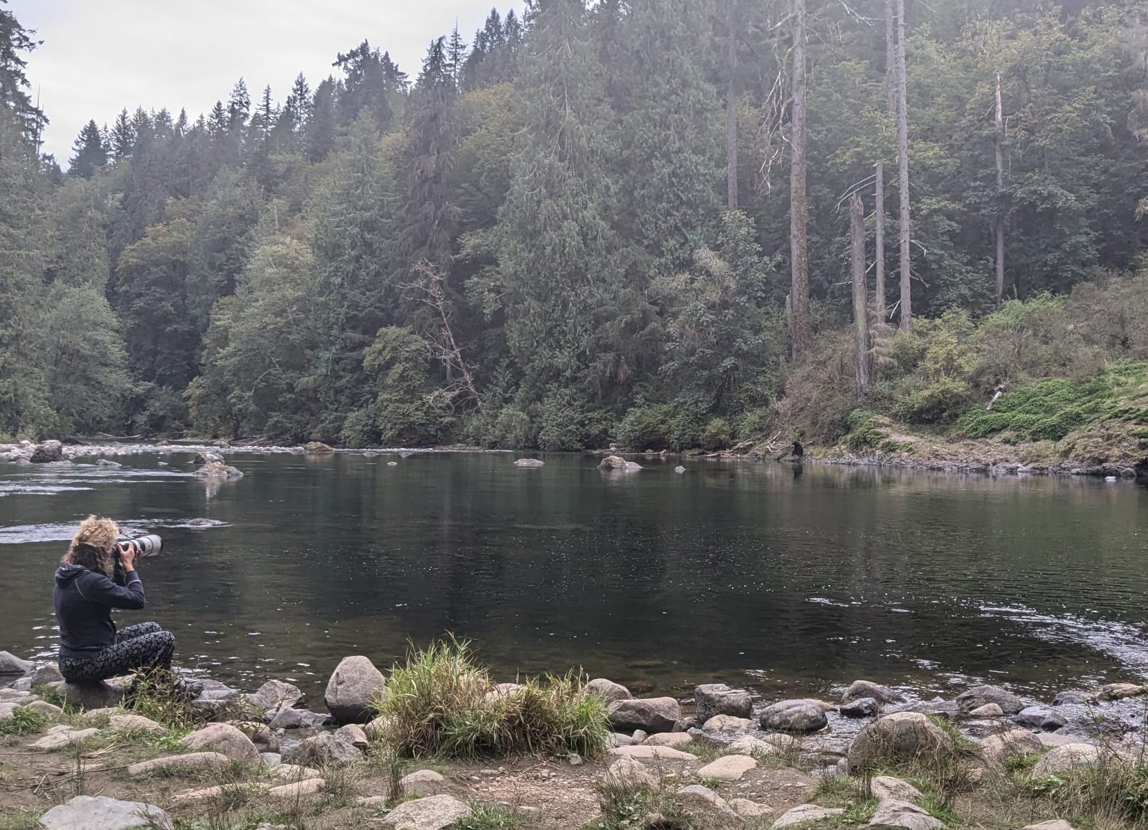 Jasmijn fotografeert aan de rand van een rivier in de natuur